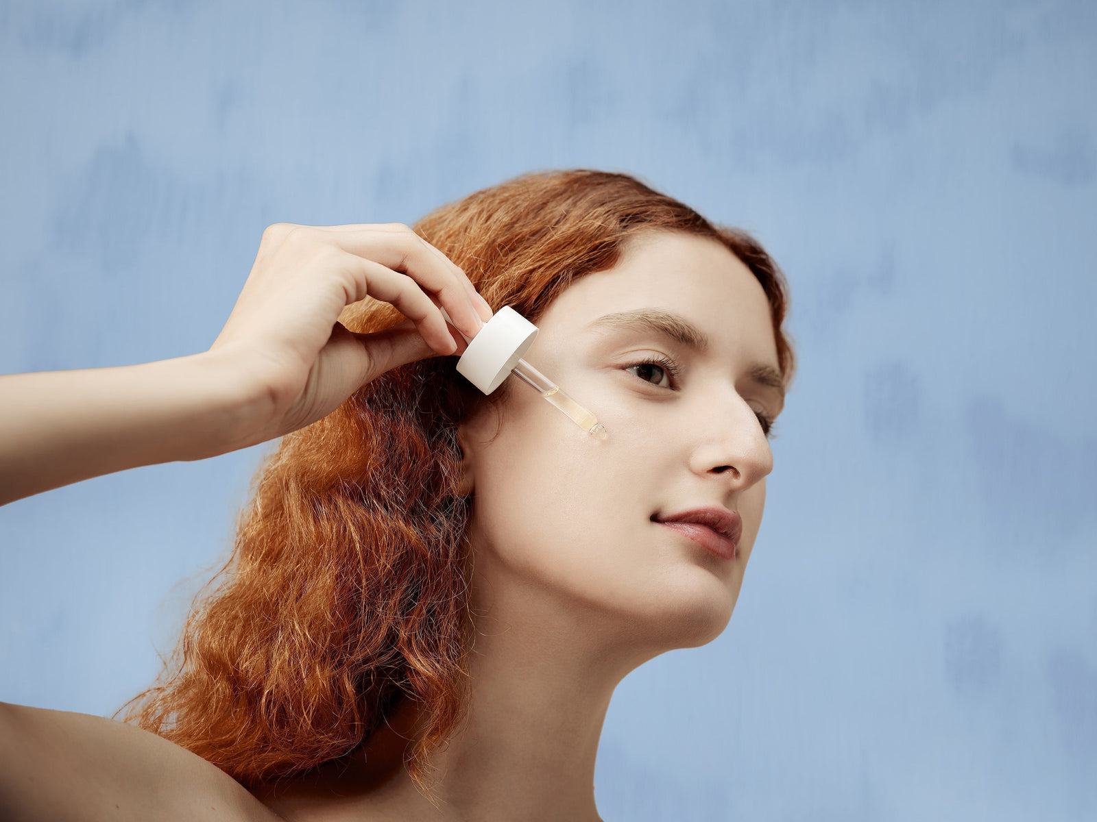 Woman applying serum on her face