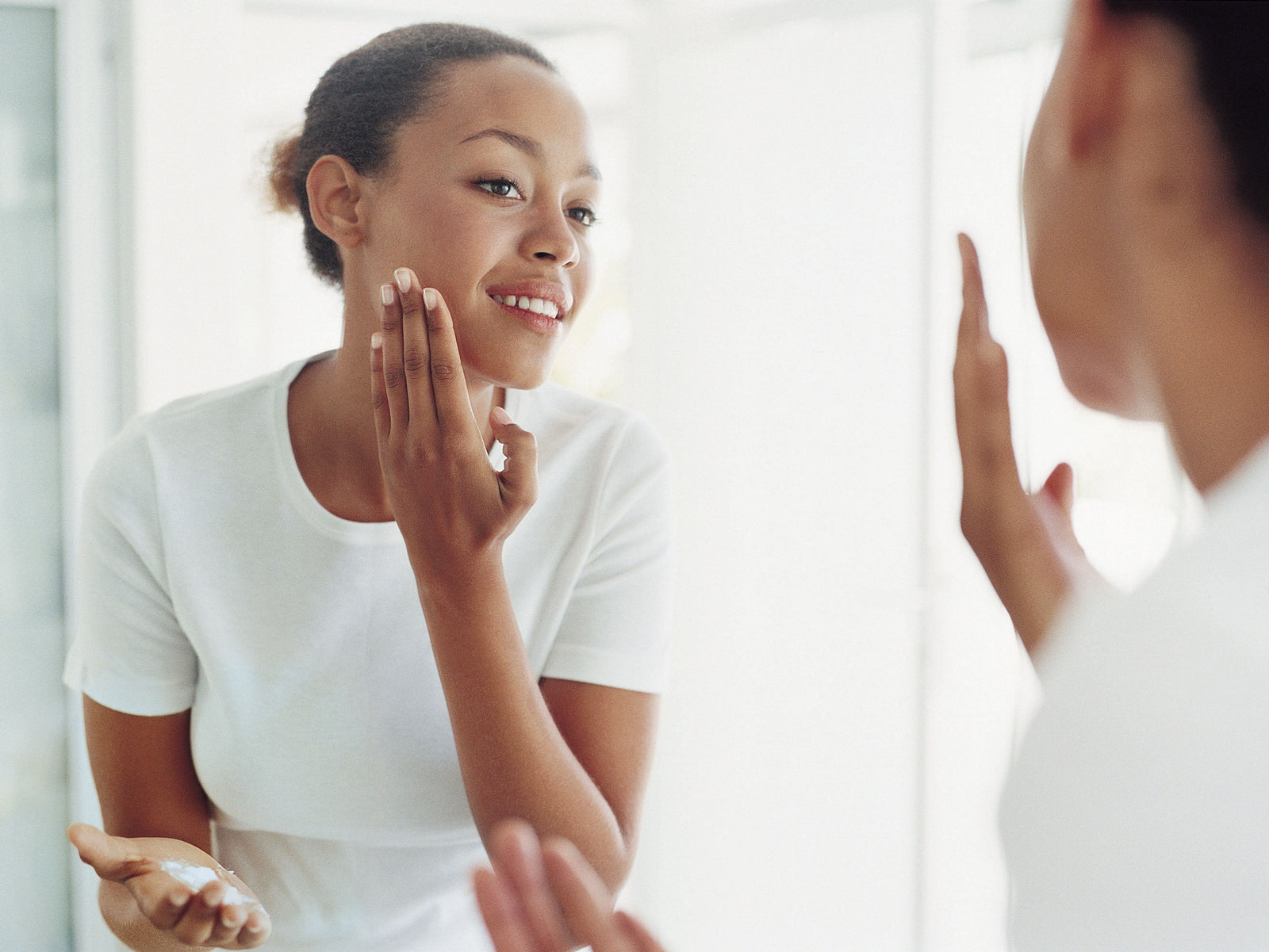 woman applying serum on her face