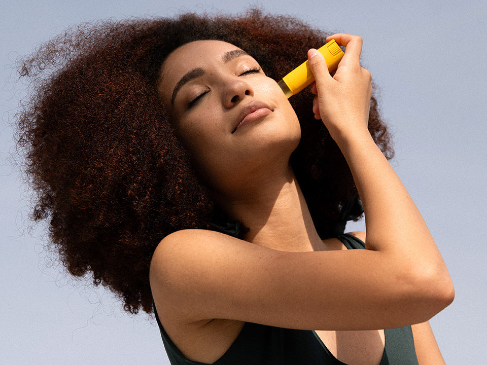 woman applying stick spf on her face