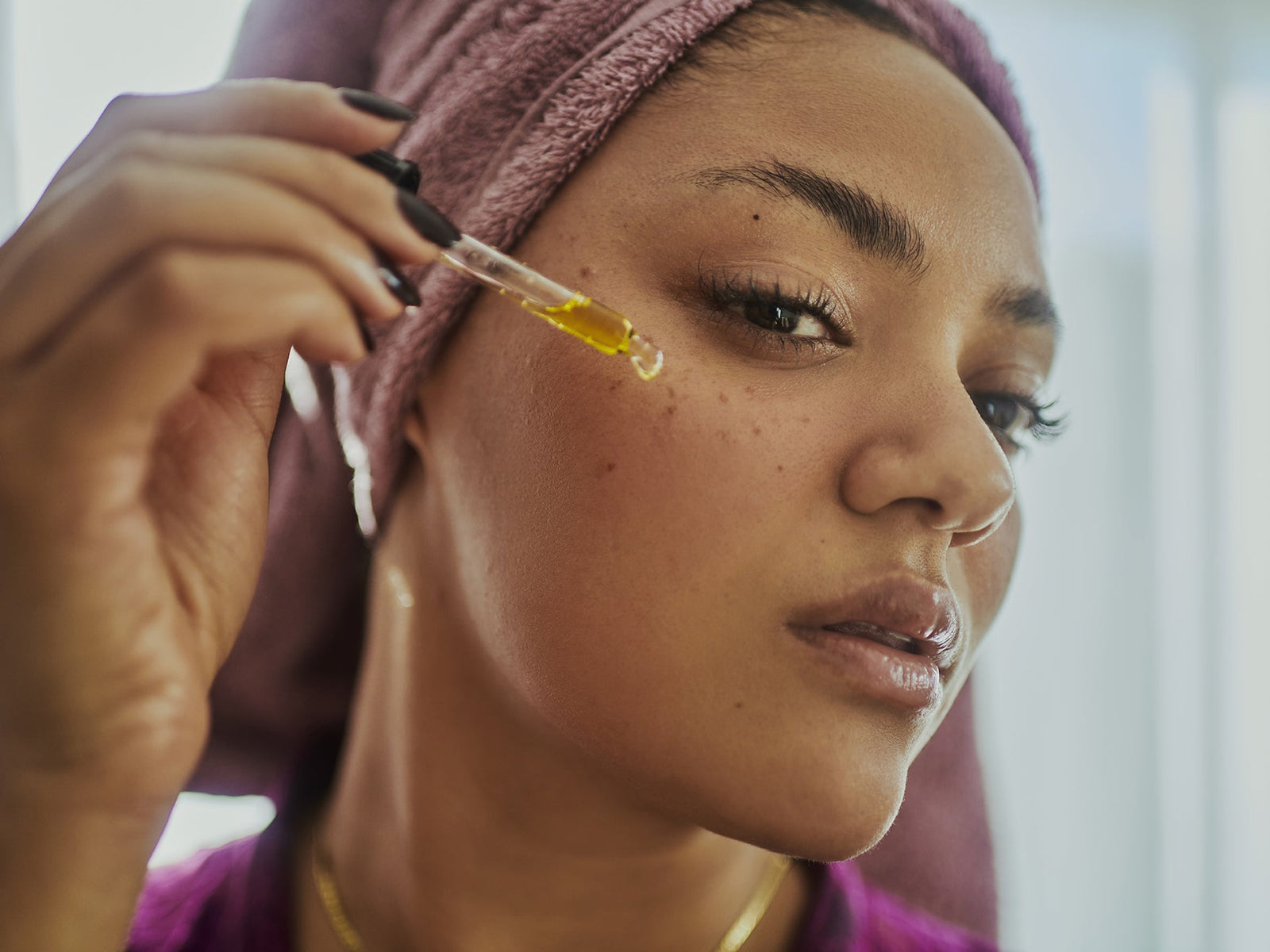 woman applying serum on her face